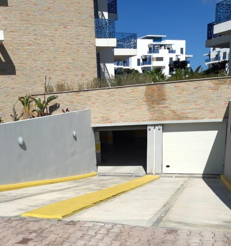 a garage with two white doors and a building at Appartement de Luxe MARTIL COSTA MAR Pour Familles in Martil