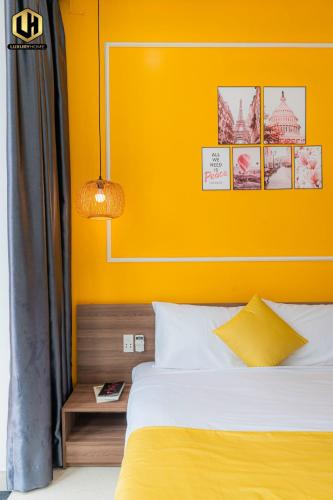 a bedroom with a bed with a yellow wall at Luxury Condotel Sai Gon 2 in Ho Chi Minh City