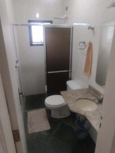 La petite salle de bains est pourvue de toilettes et d'un lavabo. dans l'établissement Condomínio Village Tabatinga 12, à Ubatuba
