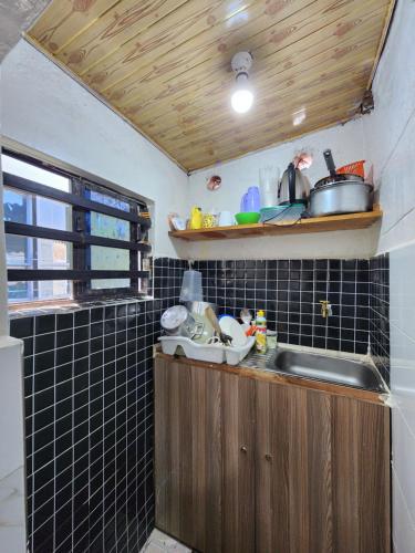 una pequeña cocina con fregadero y ventana en Tiny 1 Bedroom with wifi and secure parking, en Kisumu