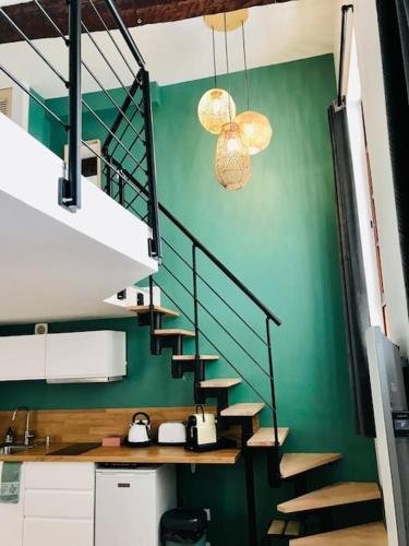 eine Treppe in einem Zimmer mit einer grünen Wand in der Unterkunft Au coeur du quartier historique in Montpellier