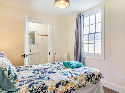 a bedroom with a bed and a window at Lovely Primrose Cottage Torquay in Torquay