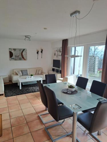 een eetkamer en een woonkamer met een tafel en stoelen bij Ferienhäuser Rhön - Haus Natalie & Haus Helene in Hausen