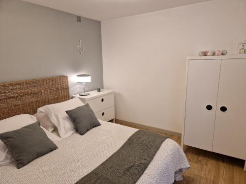 um quarto com uma cama e um armário branco em La cour em Honfleur