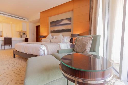 a hotel room with a bed and a table at Four Apple EMAAR Fashion Avenue Studio in Dubai