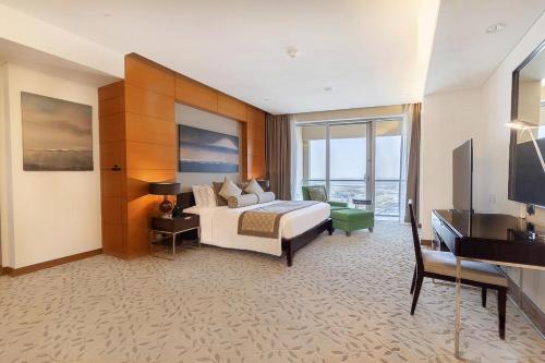 a hotel room with a bed and a television at Four Apple EMAAR Fashion Avenue Studio in Dubai