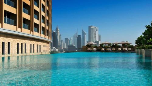 a large pool of water in front of a city at Four Apple EMAAR Fashion Avenue Studio in Dubai