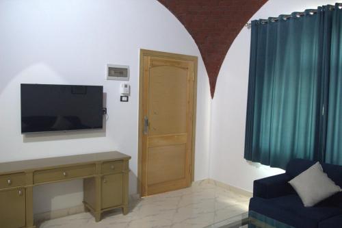 a living room with a flat screen tv and a door at Mogran Guest House in Luxor