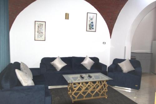 a living room with a black couch and a table at Mogran Guest House in Luxor
