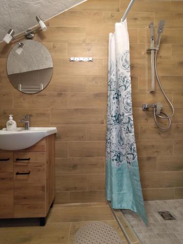 a bathroom with a shower curtain and a sink at Radikiai House 
