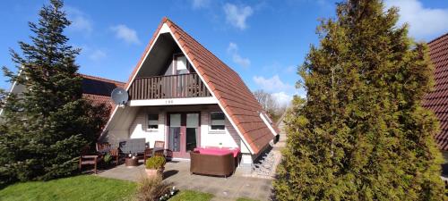 a house with a gambrel roof with a porch at Ferienhaus Rosenthal in Anjum