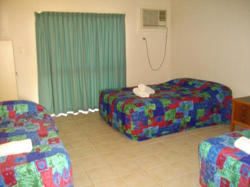 a living room with two chairs and a couch at Kurrimine Beach Motel in Kurrimine Beach