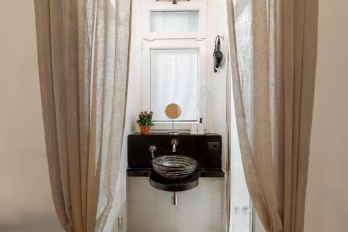 een badkamer met een wastafel en een raam bij Fiori Suite in Rome
