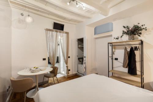een slaapkamer met een wit bed en een tafel en stoelen bij Fiori Suite in Rome
