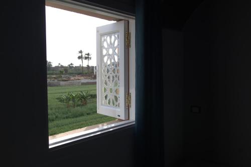 an open window with a view of a field at Mogran Guest House in Luxor
