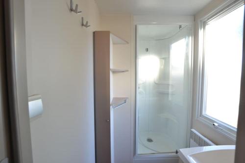 uma casa de banho com uma cabina de duche em vidro e um lavatório. em La Marine 4* - Mobil Home 3ch - 6 couchages em Le Grau-du-Roi