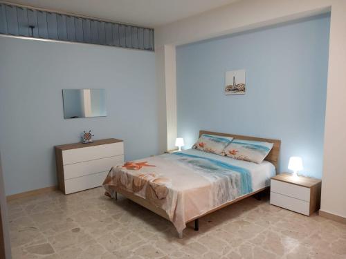 a bedroom with a bed with two night stands and two tables at MareFuori in Giardini Naxos