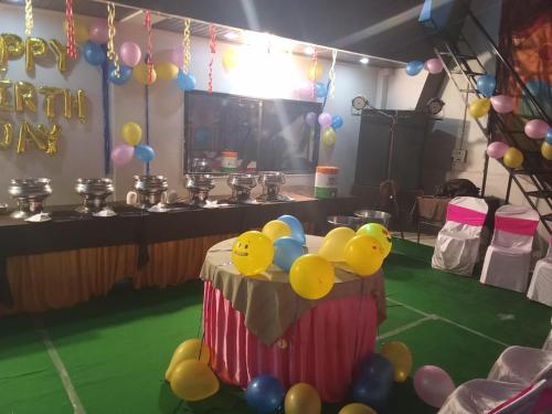 a birthday party with a cake and balloons on a table at Hotel New Food Restrorent in Ujjain