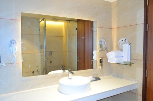 a bathroom with a sink and a mirror at The Aurum Subrahmanya in Subrahmanya