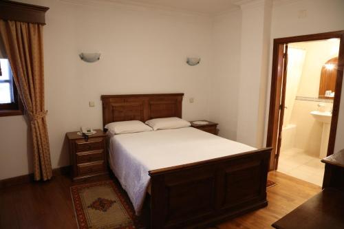a bedroom with a large bed and a bathroom at Casa de Sao Cristovao in Boticas