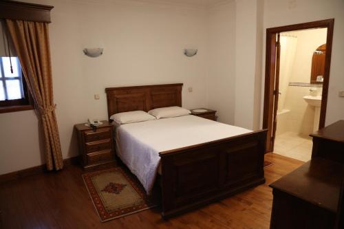 a bedroom with a large bed and a bathroom at Casa de Sao Cristovao in Boticas