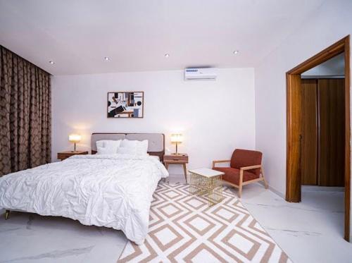 Un dormitorio con una cama grande y una silla. en KEUR YAYE FA, en Dakar
