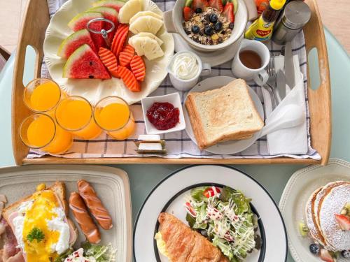 two trays filled with breakfast foods and orange juice at Royal Beach View in Pattaya South