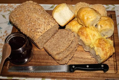 a wooden cutting board with sandwiches and a knife at Munsterland Guest Farm in Outjo