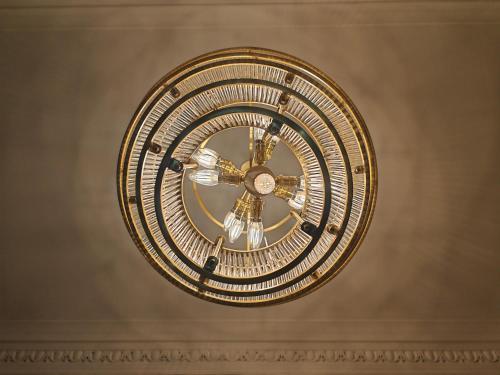 a large gold clock hanging on a wall at Frederick House Hotel in Edinburgh