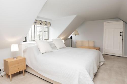 Un dormitorio blanco con una cama blanca y una ventana en Summer Gaze House, en Harpsden