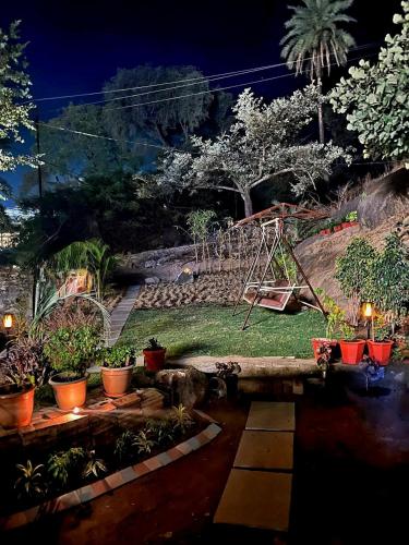a garden with a swing set and potted plants at EMINENCE - PALM RESIDENCY (1.5 KM FROM NAKKI LAKE) in Mount Ābu