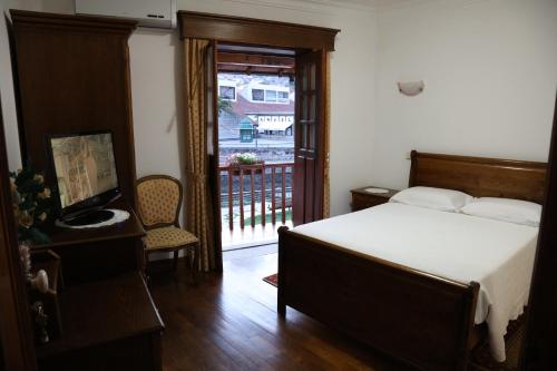 a bedroom with a bed and a door to a balcony at Casa de Sao Cristovao in Boticas