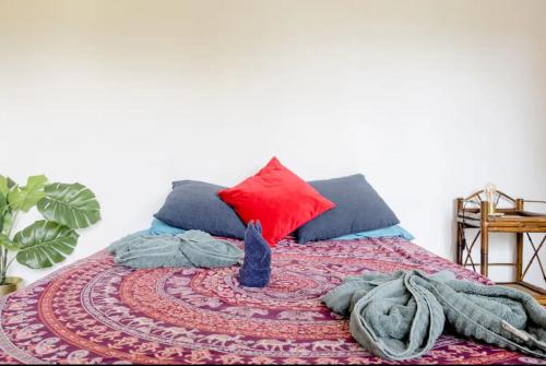 a bed with a red and blue blanket and pillows at Casa Patricia in Uvita