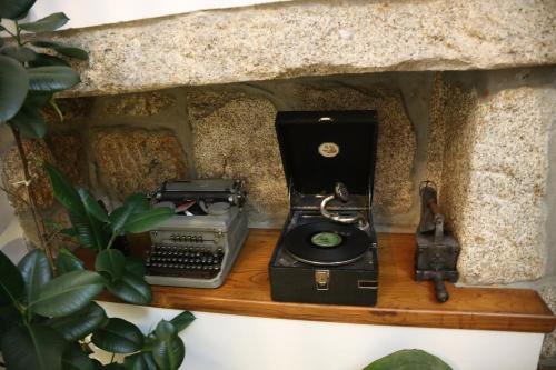 an old fashioned telephone and a typewriter on a shelf at Casa de Sao Cristovao in Boticas