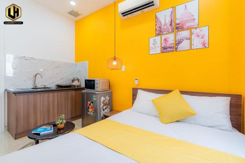 a bedroom with a bed and a yellow wall at Luxury Condotel Sai Gon 2 in Ho Chi Minh City
