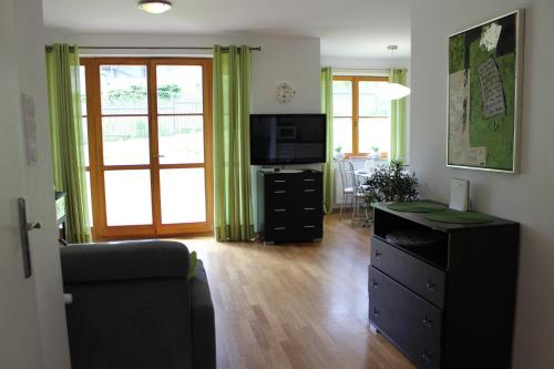 a living room with a black dresser and a television at "Apartament Przy Stoku Karpatka" na osiedlu "Apartamenty pod Śnieżką" in Karpacz