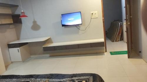 a living room with a tv on a wall at Hotel New Food Restrorent in Ujjain