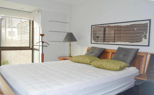 een wit bed met twee kussens erop bij Barranco Cozy Apartment in Lima