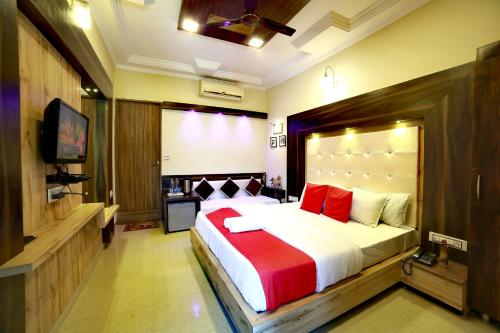 a bedroom with a large bed and a television at EMINENCE - PALM RESIDENCY (1.5 KM FROM NAKKI LAKE) in Mount Ābu