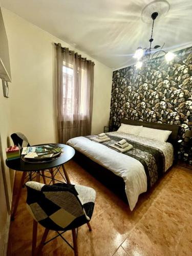 a bedroom with a bed and a table with a chair at Casa EdEn in Isolabona