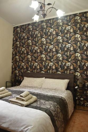 a bedroom with a large headboard with a wall covered in animals at Casa EdEn in Isolabona