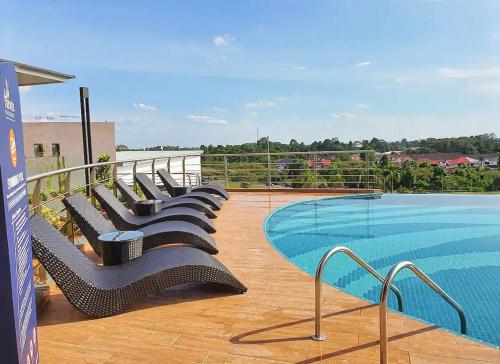 - une rangée de chaises assises à côté de la piscine dans l'établissement Hann's Residence Homestay City View 2R2B, à Sibu