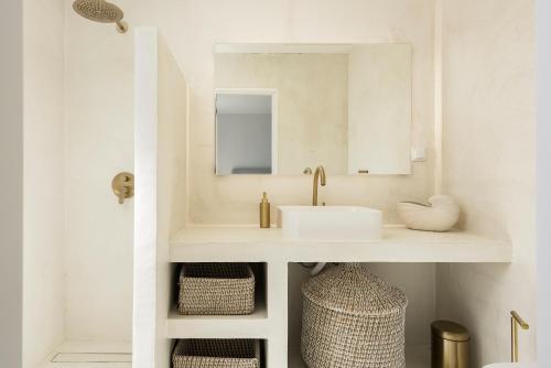 a white bathroom with a sink and a mirror at Modern Retreat: 3 Bedroom Villa in the Old Village in Quarteira