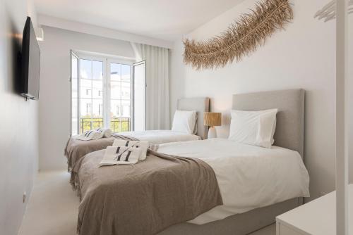2 camas en una habitación con paredes blancas en Modern Retreat: 3 Bedroom Villa in the Old Village, en Quarteira