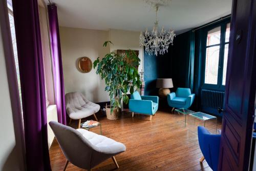un salon avec des chaises bleues et un lustre dans l'établissement Le Jardin, chambres d'hôtes en Baie de Somme, à Cahon