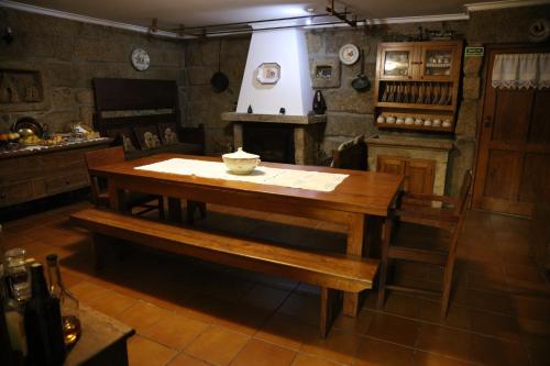 a wooden table and bench in a kitchen at Casa de Sao Cristovao in Boticas