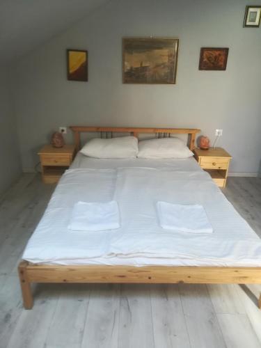 een slaapkamer met een groot bed met witte lakens bij Selatt in Balatonfüred