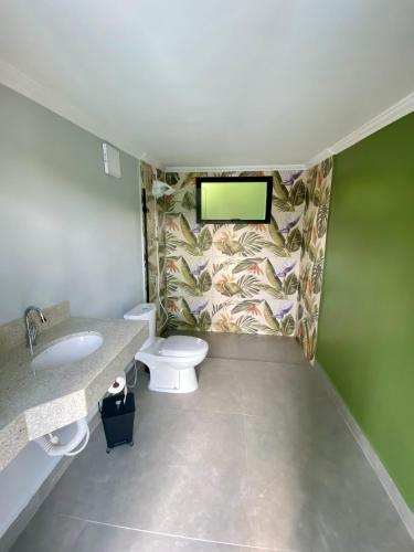 un baño con inodoro y lavabo en Suítes Por do Sol, en Cabreúva