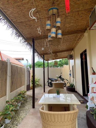 a patio with a table and chairs and a chandelier at Mingche Apartment in Panglao
