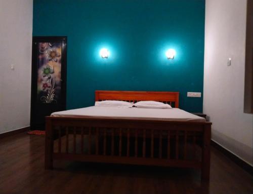 paddy farm varkala في فاركَالا: سرير في غرفة ذات جدار ازرق